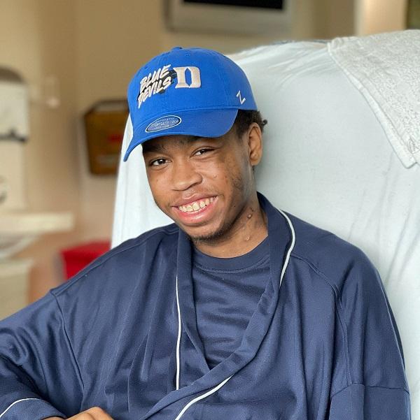 A heart transplant recipient smiles from his bed.