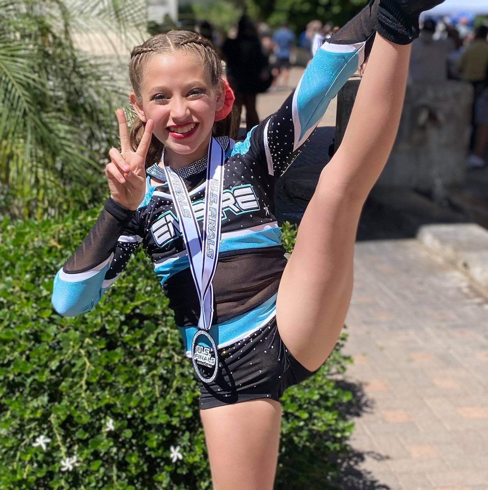 Viktoria is a youth cheerleader pictured in her cheerleading competitive uniform and smiling.