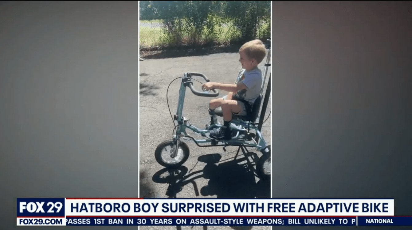A screenshot of a news broadcast from FOX 29 Philadelphia shows 4-year-old Vinny riding his new adaptive bike with the caption HATBORO BOY SURPRISED WITH FREE ADAPTIVE BIKE.