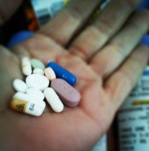 the cost of diabetes and medical expenses. hand holding pills